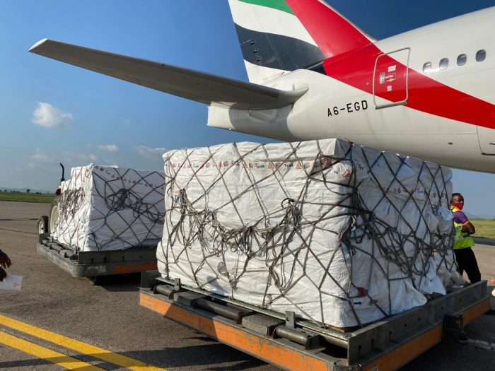 Palletised air freight on dollies beside the wing of a cargo aircraft