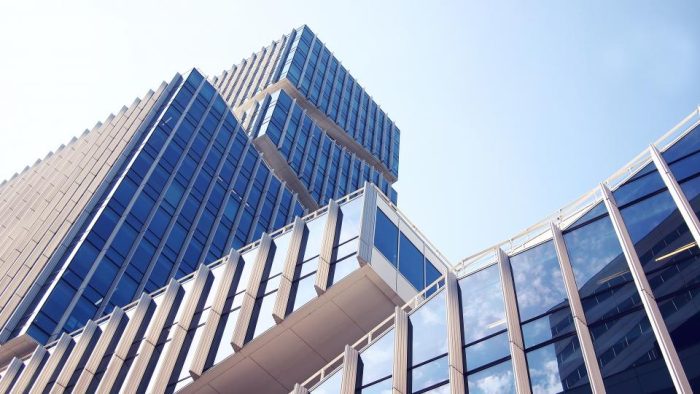 Modern blue glass commercial office towers seen from below